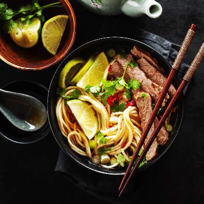 A bowl of Thai noodles with chop sticks